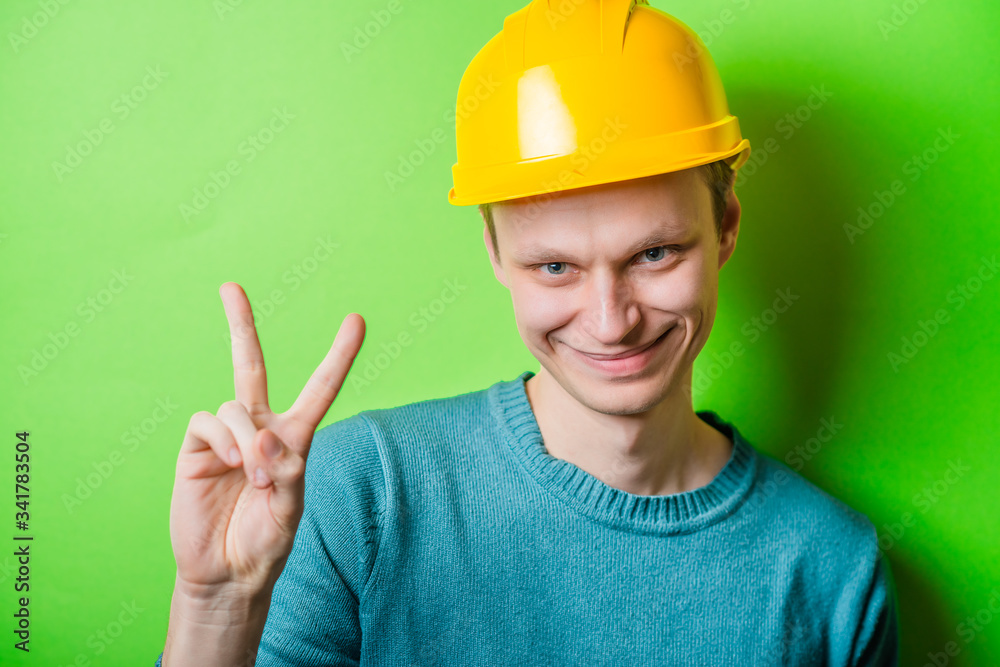 Happy smiling construction worker  showing two fingers or victory gesture