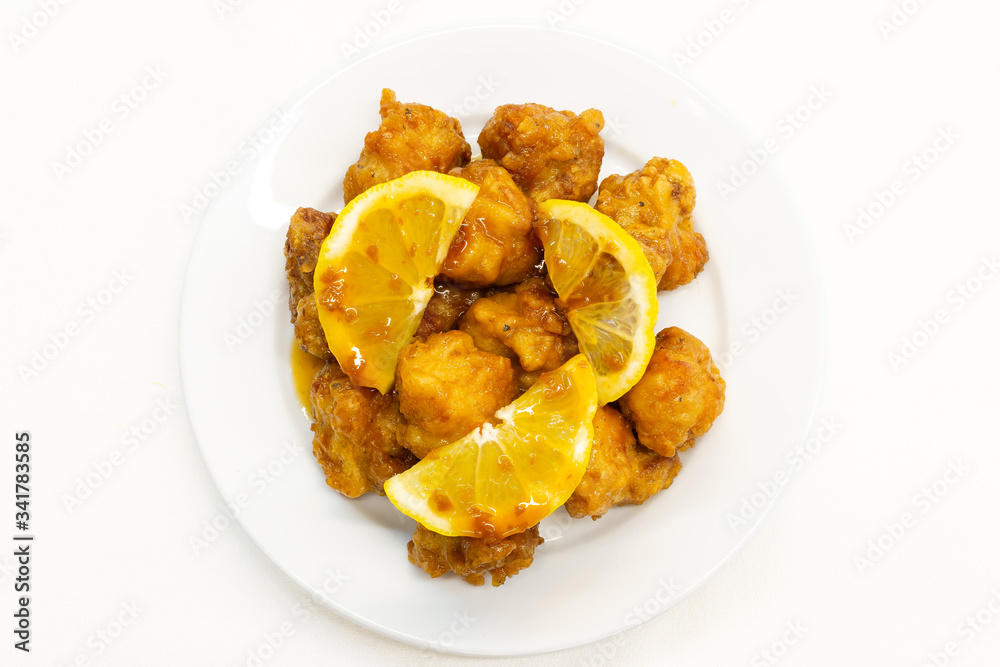 Chinese Lemon Chicken on white background.This Chinese Lemon Chicken is made with boneless skinless chicken thigh, cut into bite-size pieces and fried until golden and crispy. Chinese Lemon Chicken on white background.This Chinese Lemon Chicken is made with boneless skinless chicken thigh, cut into bite-size pieces and fried until golden and crispy.