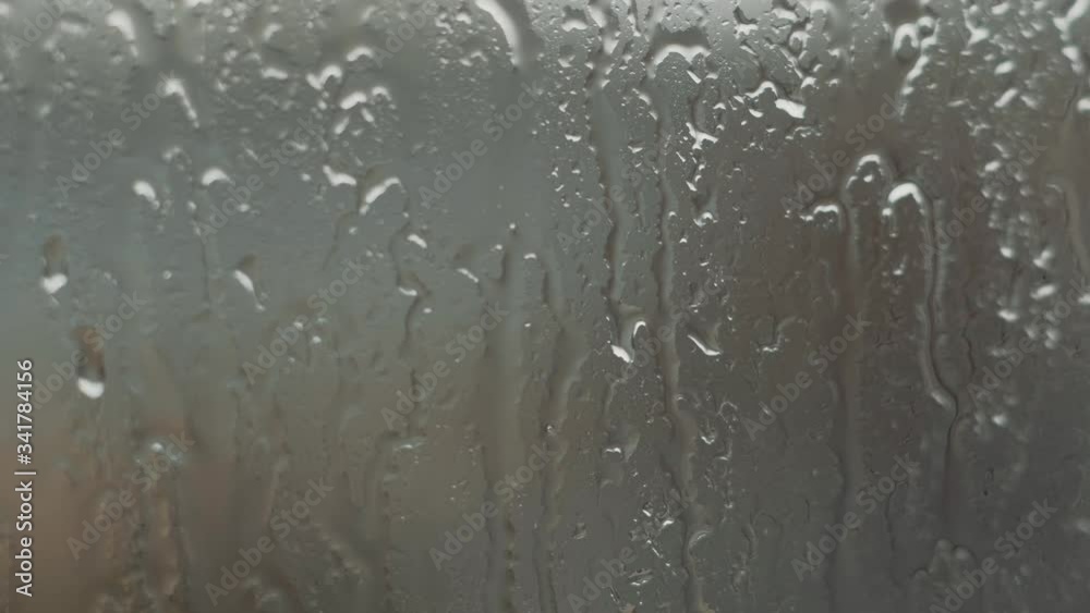 Close up of a window with rain drops falling down, Heavy rain on window. Rain splashing on a window, over a cloudy blue sky. ULTRA HD. 4K. Close up of a window with rain drops falling down, Heavy rain on window. Rain splashing on a window, over a cloudy blue sky. ULTRA HD. 4K.