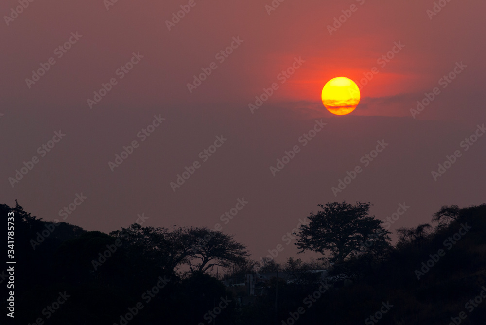 Setting the Sun at dusk from Guatemala City, silhouetted by mountains and trees, peaceful dusk in the middle of the Covid 19 pandemic Central America. Setting the Sun at dusk from Guatemala City, silhouetted by mountains and trees, peaceful dusk in the middle of the Covid 19 pandemic Central America.