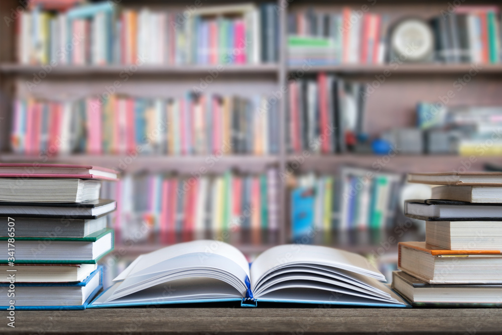 Books and textbook on wooden desk in library selective focus , Piles of books on reading desk in school with copy space for text.World book day and education concept. Books and textbook on wooden desk in library selective focus , Piles of books on reading desk in school with copy space for text.World book day and education concept.
