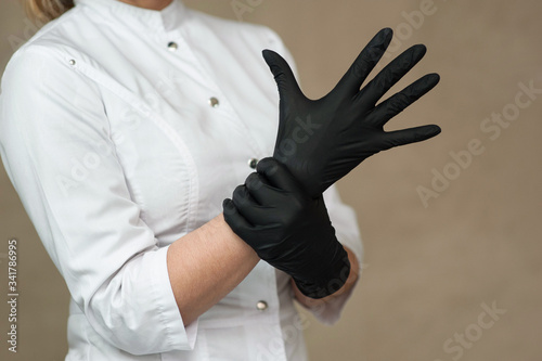 beautician in black medical gloves