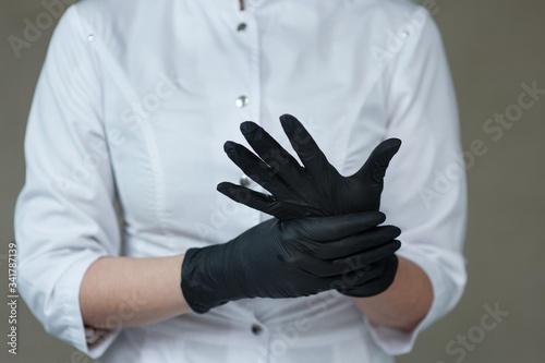 medical worker in black medical gloves and a black medical mask