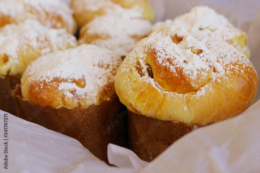 Fresh bakery, cropped shot. Fresh buns with powdered sugar, close up view. 
