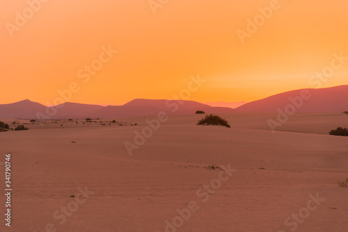 colorful sunset over desert sand dunes