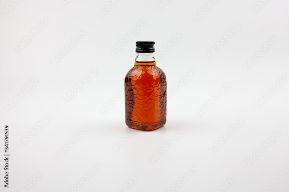A small bottle of brown liquid that looks like rum. Indian rum. A small bottle of brown liquid that looks like rum. Indian rum.