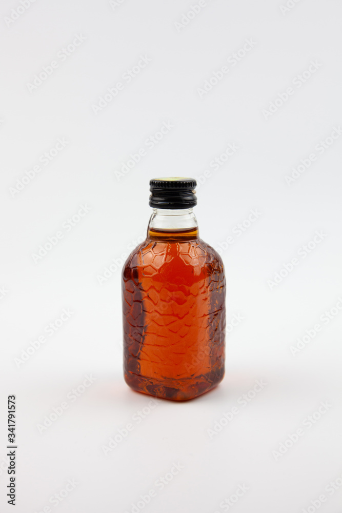A small bottle of brown liquid that looks like rum. Indian rum.
