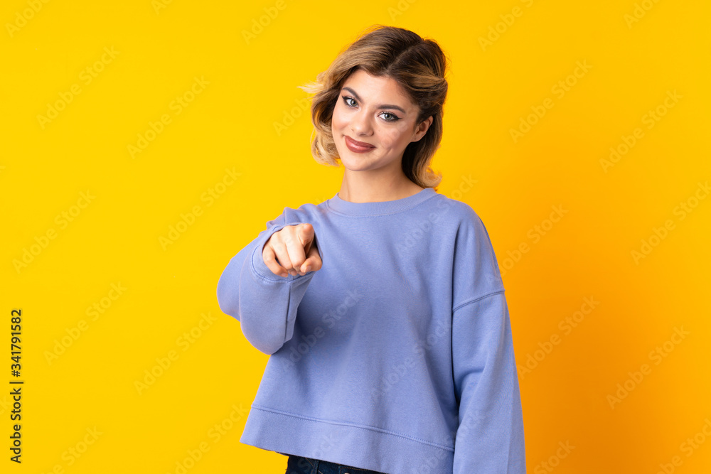 Young Russian woman isolated on yellow background pointing front with happy expression Young Russian woman isolated on yellow background pointing front with happy expression
