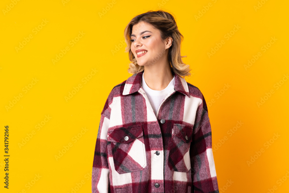 Young Russian woman isolated on yellow background looking side Young Russian woman isolated on yellow background looking side