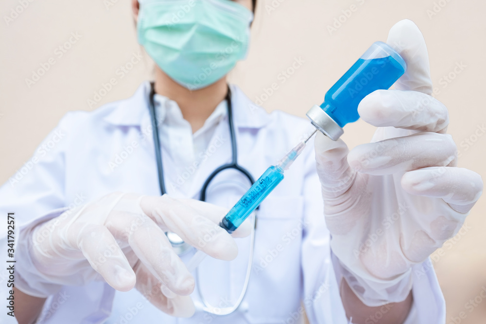 The doctor's hand is holding a blue serum tube and syringe The doctor's hand is holding a blue serum tube and syringe