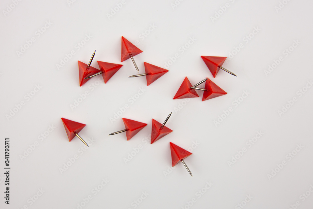 Red paper pins on a white background. A tool for attaching paper to the wall. Red paper pins on a white background. A tool for attaching paper to the wall.