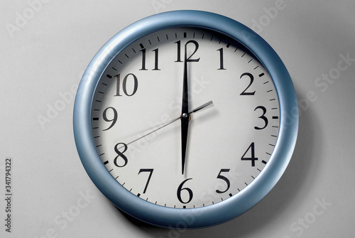 An analog wall clock displaying 6 o'clock.