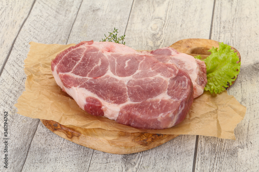 Raw pork steak over wooden board Raw pork steak over wooden board