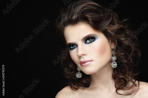 Young beautiful woman with curly hair and fancy smoky eye makeup