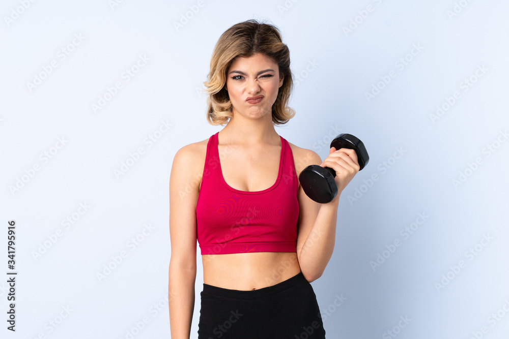 Teenager Russian girl making weightlifting isolated on blue background with sad expression Teenager Russian girl making weightlifting isolated on blue background with sad expression