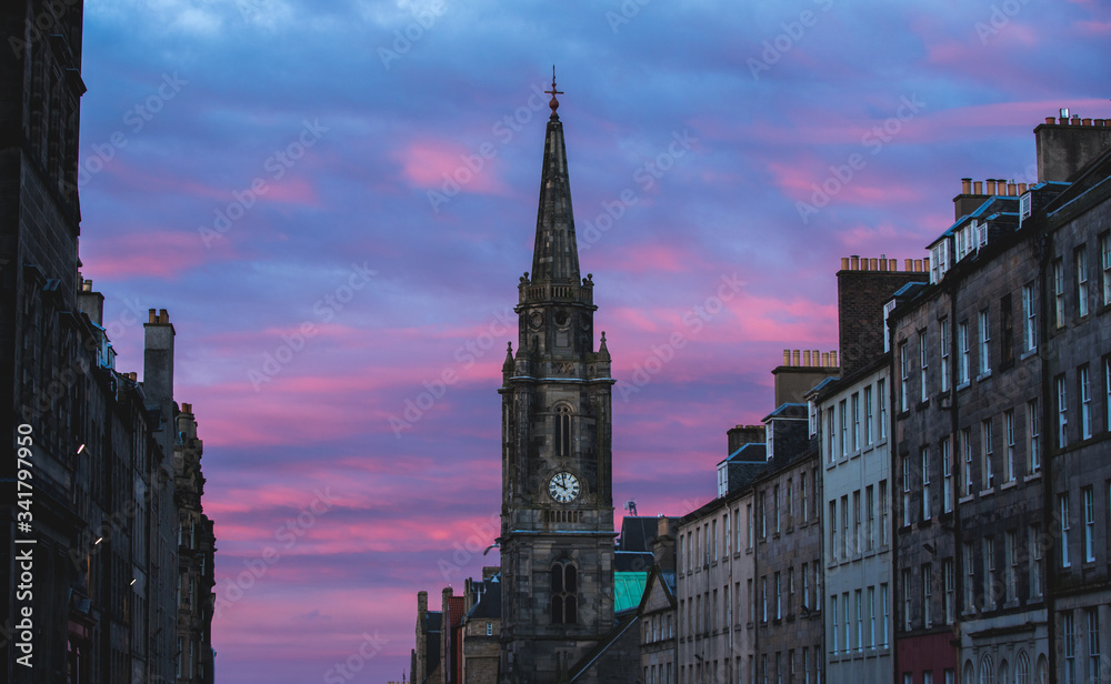 Clock tower in Edinburgh on purple sunset. Historic building Clock tower in Edinburgh on purple sunset. Historic building