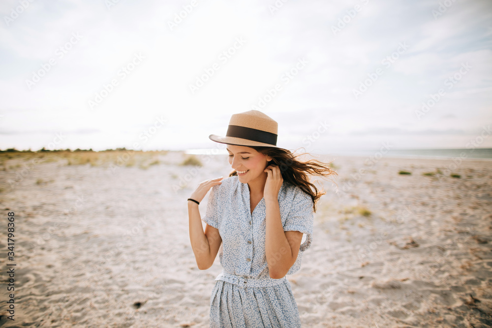 Young beautiful girl in a hat on the beach
