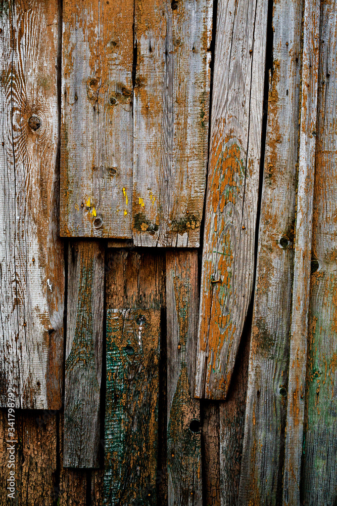 An old wall of wooden planks with traces of old paint
