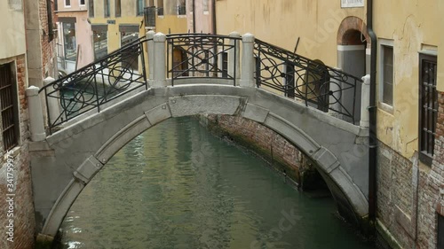 Middle shot footage of footbridge over water canal street on spring sunny day in Venice, Italy. Italian vacation. No people background