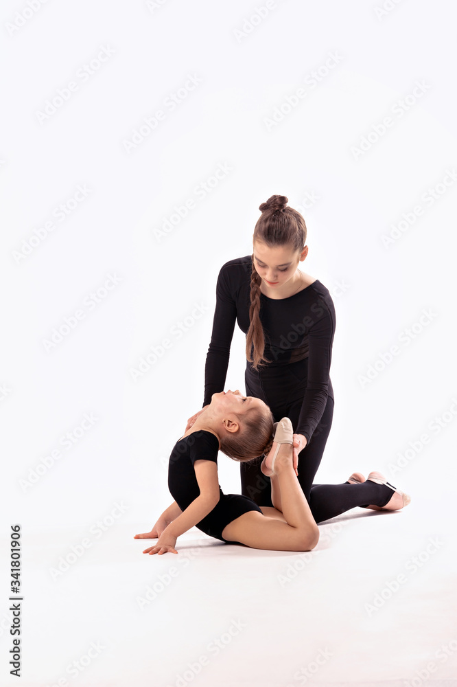 Rhythmic gymnastics. Girl gymnast and trainer perform various gymnastic exercises. Children and sports, healthy lifestyle. Rhythmic gymnastics. Girl gymnast and trainer perform various gymnastic exercises. Children and sports, healthy lifestyle.