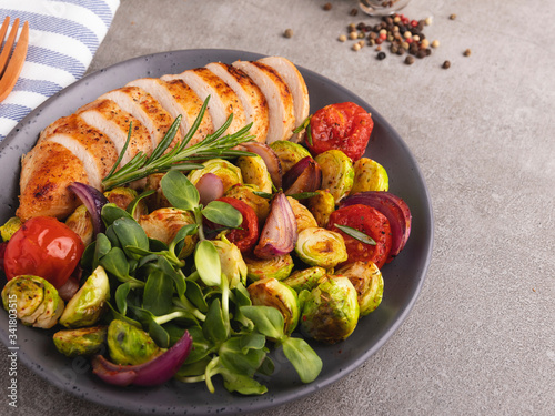 roasted sliced chicken fillet with brussels sprouts, avocado, herbs healthy food photo