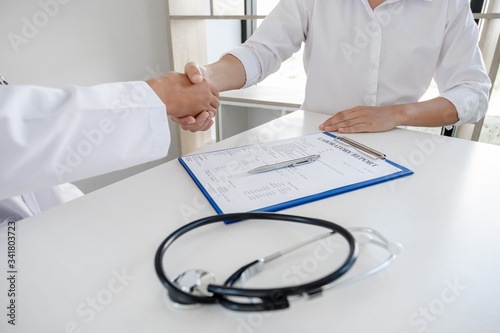 Doctors and patients shaking hands after knowing the results of the health examination, medical checkup concept