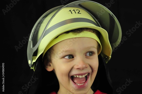 Boy with fire department helmet with the number 112