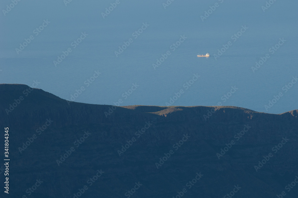 Boat sailing and cliff of the Mogan ravine. Mogan. Gran Canaria. Canary Islands. Spain. Boat sailing and cliff of the Mogan ravine. Mogan. Gran Canaria. Canary Islands. Spain.
