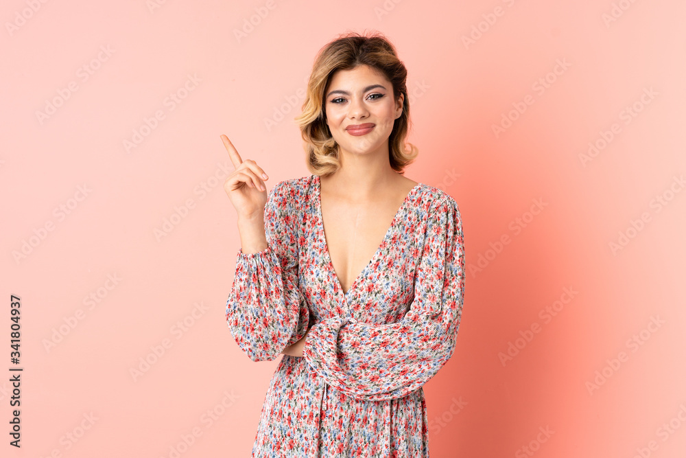 Obraz premium Young Russian woman isolated on pink background happy and pointing up