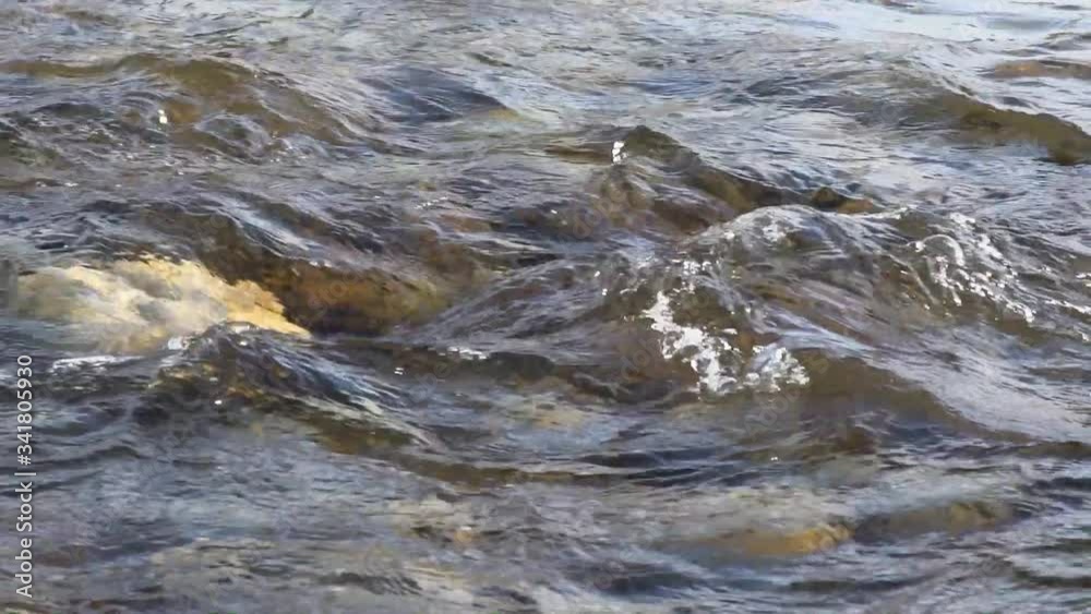 Water flowing over rocks in shallow river, slow motion video Water flowing over rocks in shallow river, slow motion video