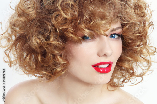 Portrait of young beautiful happy smiling woman with curly hair and red lipstick, selective focus