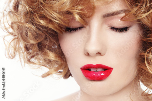 Vintage style close-up portrait of young beautiful woman with curly hair and red lipstick