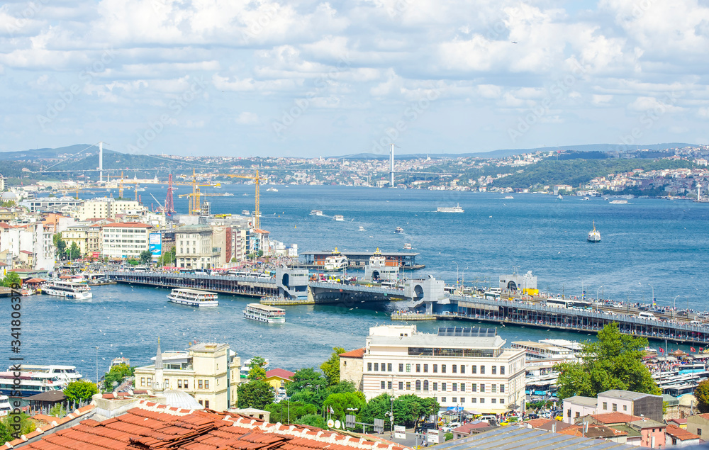 Fototapeta premium Top view of Galata bridge, Golden Horn, Bosphorus in background. White pleasure ships. Seagulls flying over water. popular tourist destination. Red tiled roofs. Turkey, Istanbul
