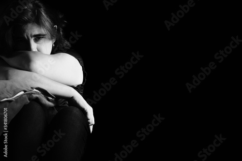 Sad and lonely woman isolated on a black background