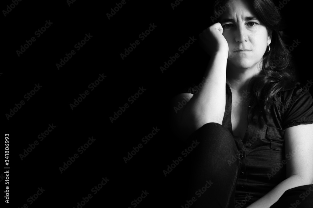 Naklejka premium Sad woman isolated on a black background - Black and white portrait