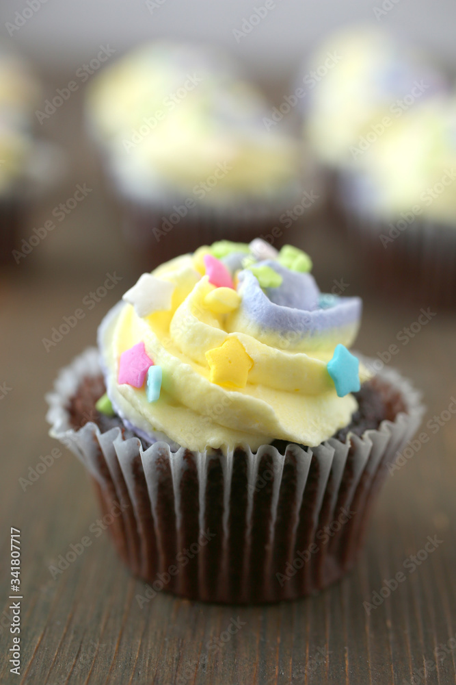 Yellow and purple easter cupcake on wooden background