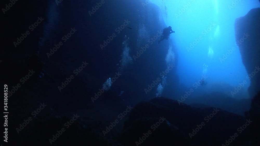 silhouette of scuba divers exploring the blue caves underwater ocean scenery silhouette of scuba divers exploring the blue caves underwater ocean scenery