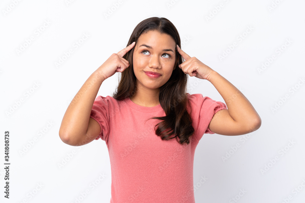 Young Colombian girl over isolated white background having doubts and thinking Young Colombian girl over isolated white background having doubts and thinking