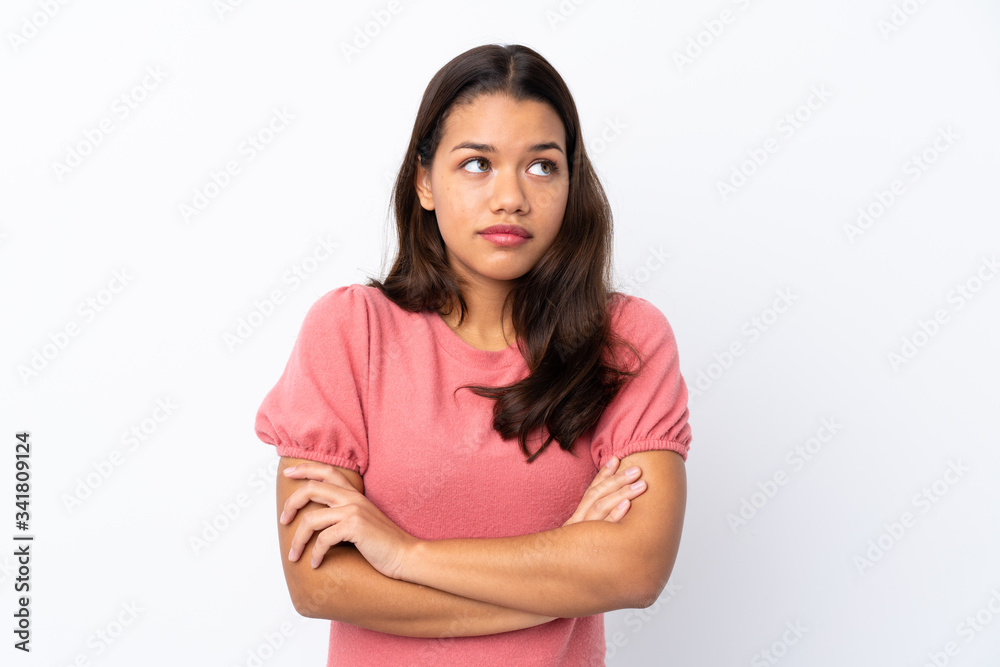 Young Colombian girl over isolated white background making doubts gesture while lifting the shoulders Young Colombian girl over isolated white background making doubts gesture while lifting the shoulders