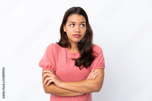 Young Colombian girl over isolated white background making doubts gesture while lifting the shoulders © luismolinero