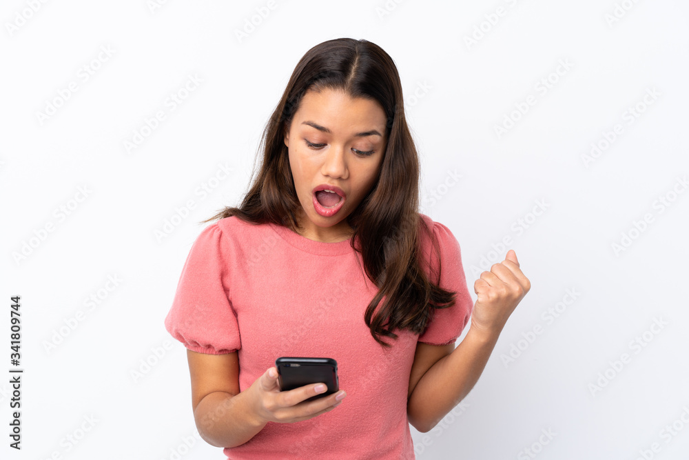 Young Colombian girl over isolated white background surprised and sending a message Young Colombian girl over isolated white background surprised and sending a message