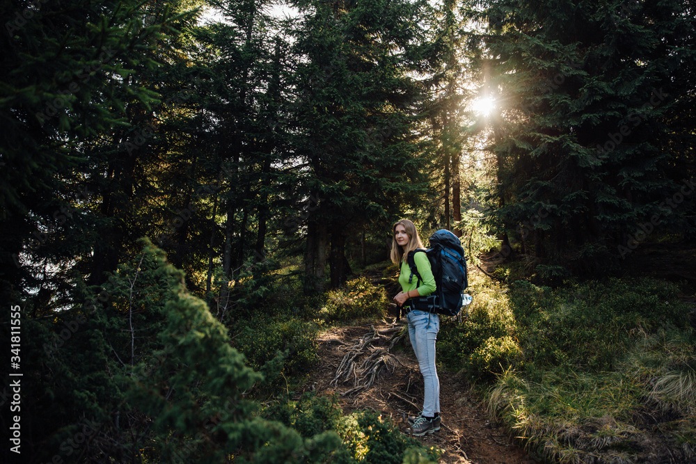 Pretty woman with backpack in forest