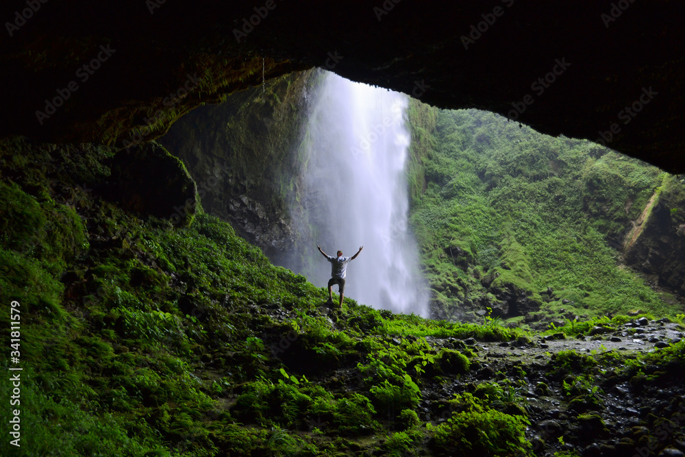 Man admiring Puxtla waterfall with arms in the air near Tlatlauquitepec in Mexico
