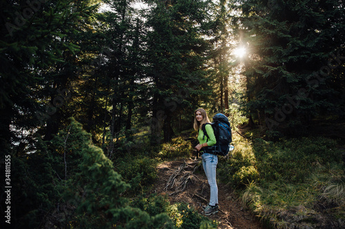 Pretty woman with backpack in forest