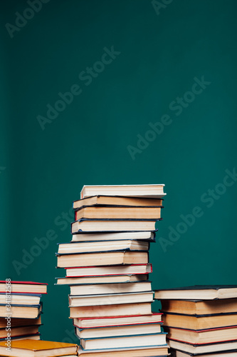 many stacks of educational books in the university library on a green background