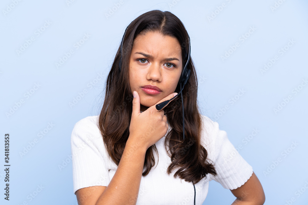 Young telemarketer Colombian woman over isolated blue background thinking an idea