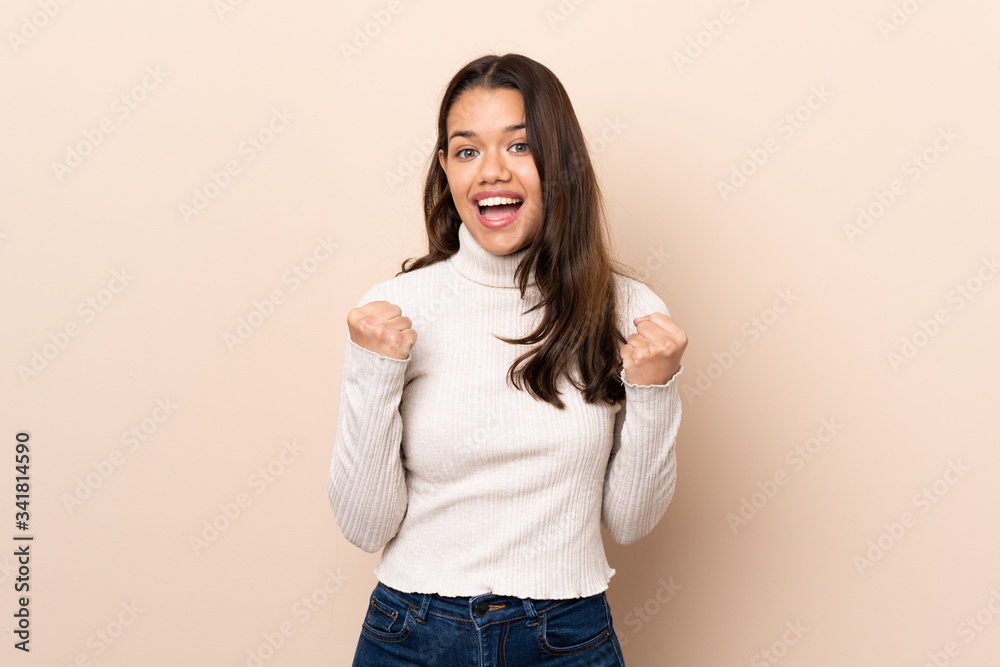 Young Colombian girl over isolated background celebrating a victory in winner position Young Colombian girl over isolated background celebrating a victory in winner position