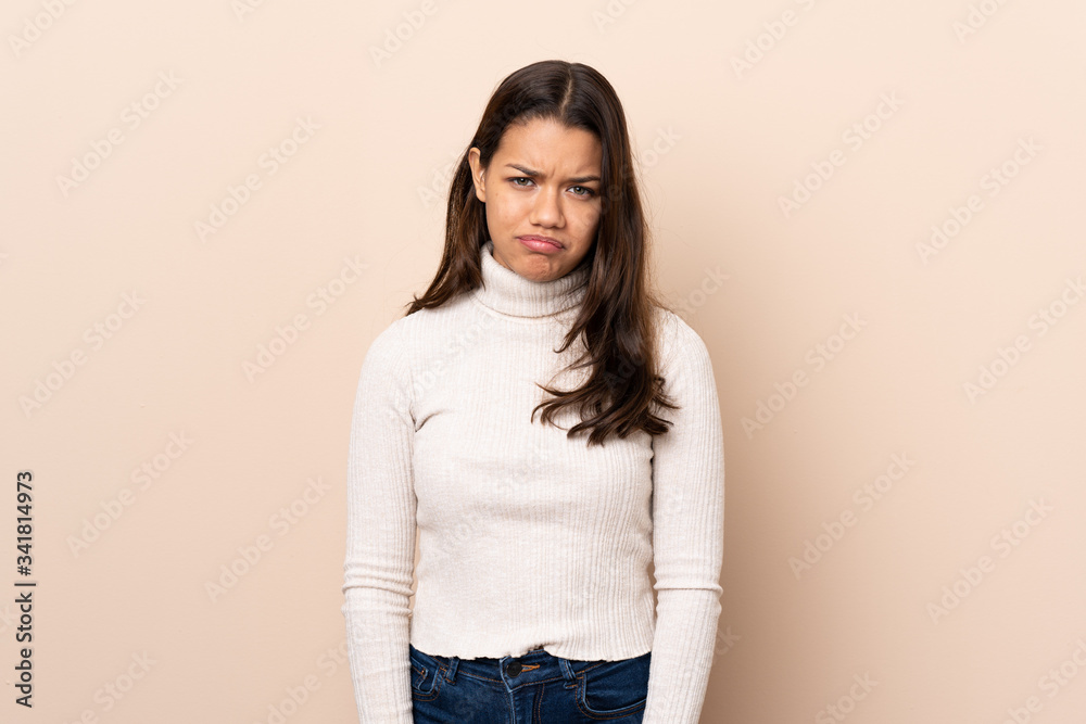 Young Colombian girl over isolated background with sad and depressed expression