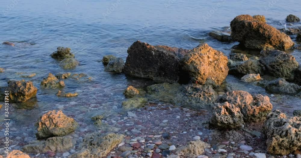 Sea. Sunlight and sun ray reflect on water surface and stones on beach. Golden light, orange and gold blue sky, Panorama Sea. Sunlight and sun ray reflect on water surface and stones on beach. Golden light, orange and gold blue sky, Panorama