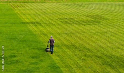 lawn mower cuts grass on the football field while working.